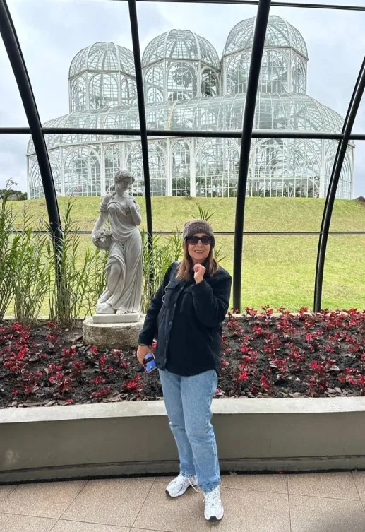Socorro Guterres. Ao fundo, o Palácio de Cristal. (Jardim Botânico. Curitiba/PR).